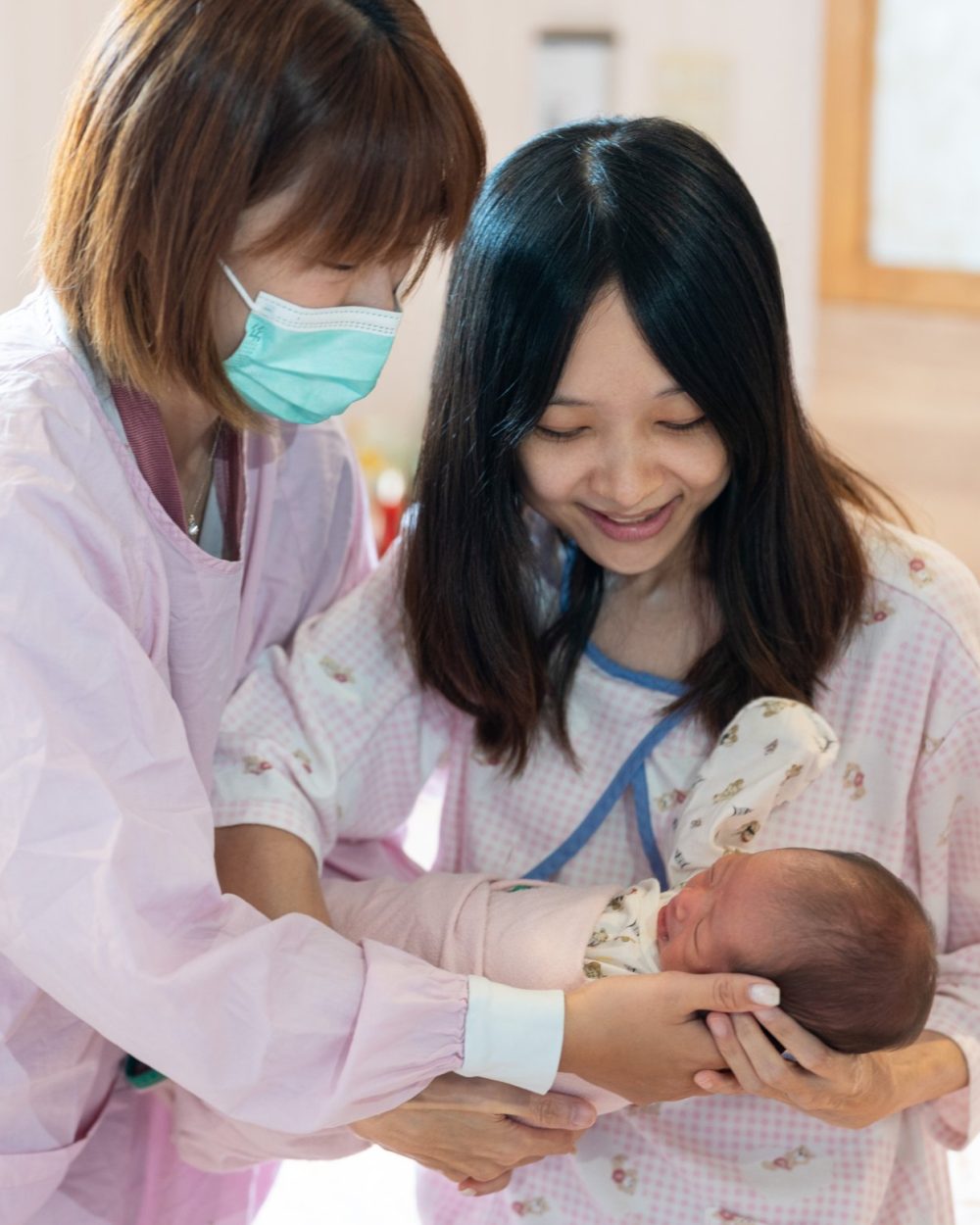 護理師陪伴媽咪抱起新生寶寶