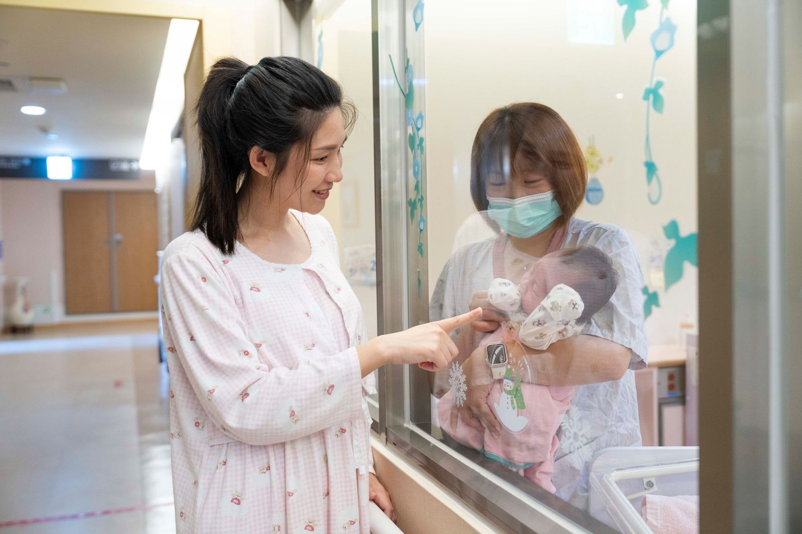媽媽隔著嬰兒室窗戶探視寶寶